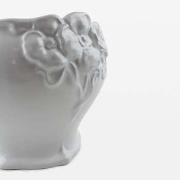 Vit kruka med blomdekor.